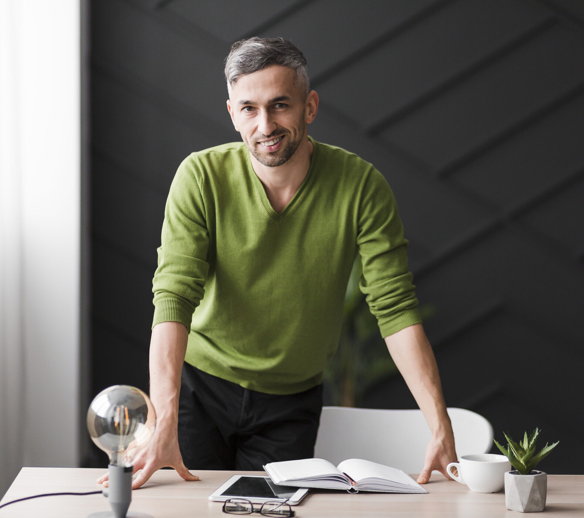 mezczyzna-w-zielonej-koszuli-stojacy-za-biurkiem